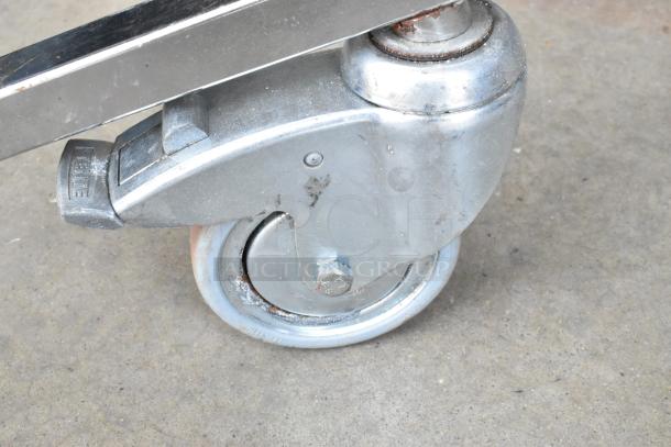 Matthews Studio Equipment tripod caster; durable metal construction, robust swivel wheel, minor rust on bolt, "TENTE" marking visible.