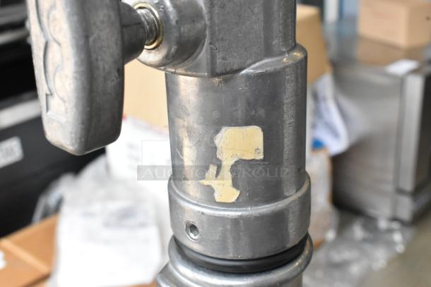 Matthews Studio Equipment tripod close-up, showing metal construction, wear marks, and labeled casters.