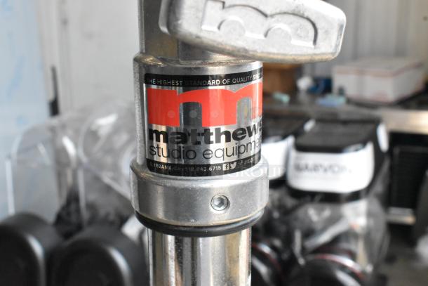 Matthews Studio Equipment tripod with sturdy metal construction. Features logo label indicating high quality. Good condition.