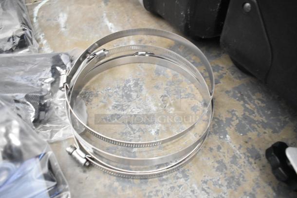 Lot of various items on a floor, including metal clamps, Kableflags, wires, and a black equipment case. Condition appears used.