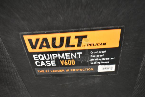 Pelican Vault V600 equipment case label, highlighting features: crushproof, dustproof, weather-resistant, locking hasps.