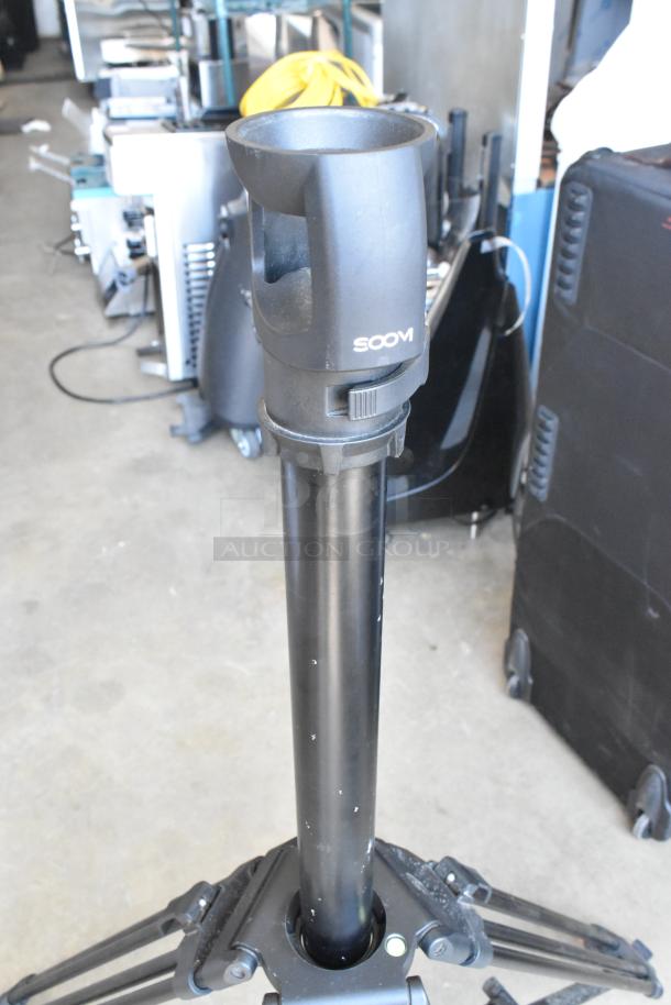 Soom tripod in soft case; sturdy design, black finish, adjustable height, used condition, includes locking mechanism.