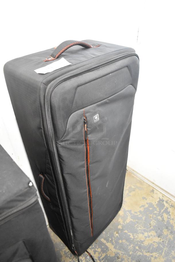 Black Kata Case with red accents; robust fabric, zippered front pocket, carrying handle; used condition.