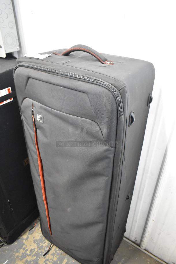 Kata Case; large black travel case with red accents; branded logo visible; zipper closure; shows light wear.