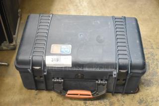 Black hard case with sturdy latches and handle, slight surface wear. Auction label: "PCI Auctions, 319". Durable construction.
