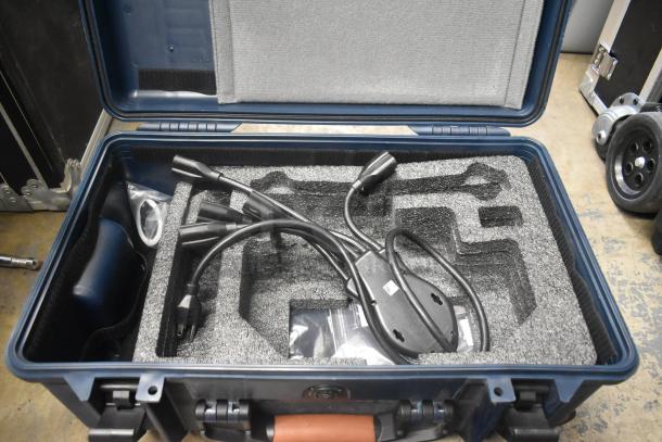 Sturdy blue hard case with foam insert, containing black electrical cables. Interior includes molded compartments.