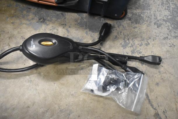 Black power strip with multiple outlets, labeled "Power Sentry," and a ziplock bag containing accessories, on a concrete floor.