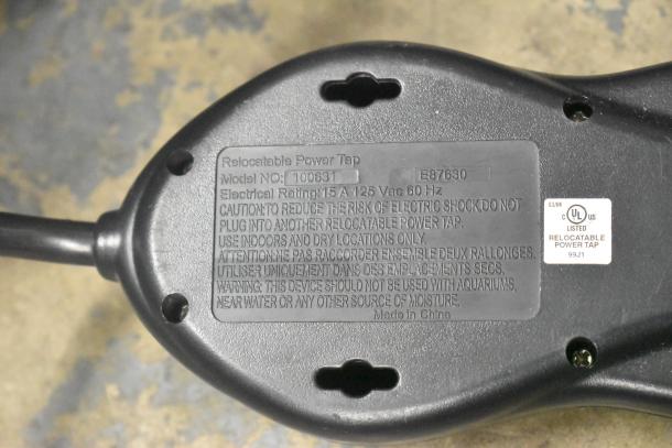Gray relocatable power tap with model number 100631, electrical rating 15A 125VAC 60Hz, caution labels for indoor dry use only.