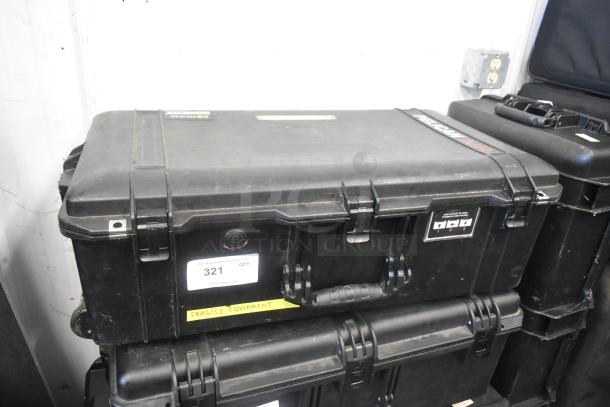 Pelican hard case containing adapters, Zip Linq, and poly containers. Durable black exterior with locking latches, labeled "Fragile Equipment."