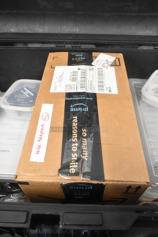Pelican hard case containing adapters, Zip Linq cables, and poly containers. Box labeled "Misc. Adapters (CC)".