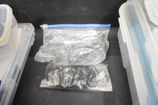 Pelican hard case contents include adapters, Zip Linq, and poly containers in clear plastic bags, organized for transport.