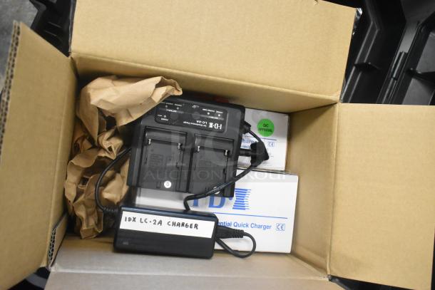 Stanley hard case with mounting hardware, clamps, extension cords, air blowers, Ethernet cables, and viewfinder inside; includes IDX LC-2A charger, boxes marked "IDX" with QC approval.