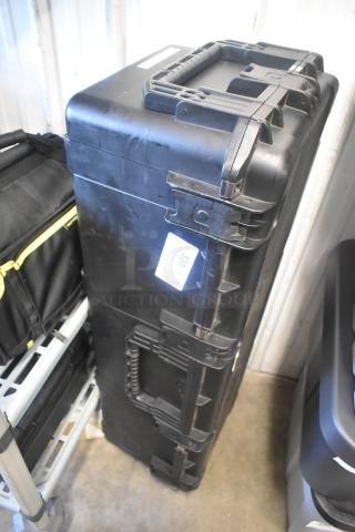 Black SKB hard case with latches and handle, standing upright. Tag reads "330." Scratches visible, indicating use.