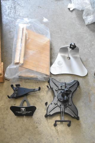 Lot of tablet stands, including RAM X-Grip with adjustable arms and ThoughtOut.biz stand. Various materials. New condition.
