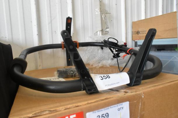 Black metal frame, in used condition, with attached cables and parts. Auction label "358", seen on cardboard box.