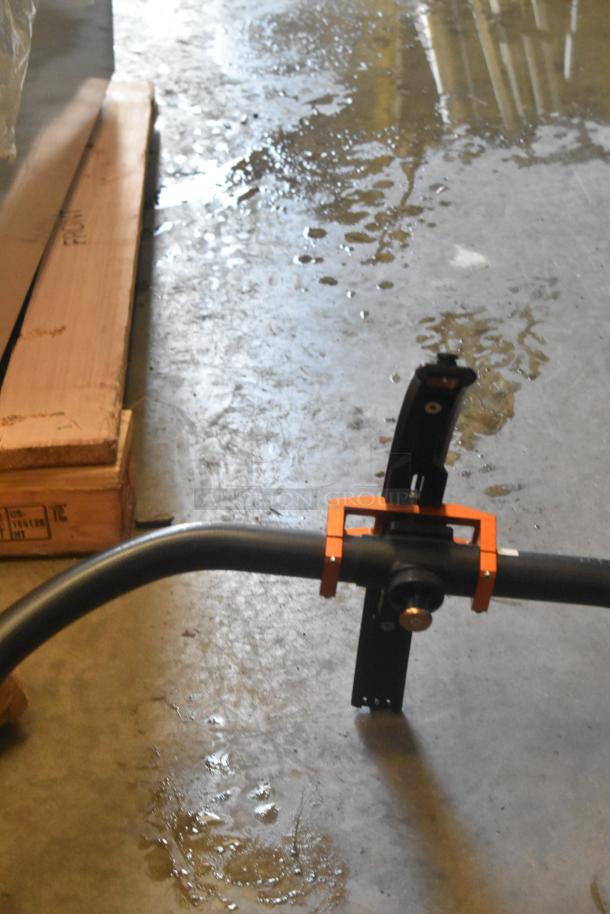 Black metal frame with orange brackets on concrete floor. Appears in good condition. No visible tags or labels.
