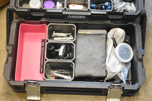 Husky poly bin with assorted hardware, including fasteners and fittings. Black exterior, organized compartments, used condition.