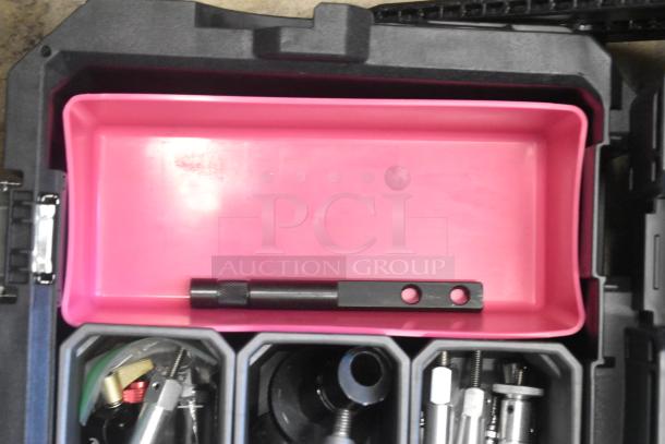 Husky poly bin with various hardware contents, including screws, bolts, and tools. Black exterior, pink inner tray visible.
