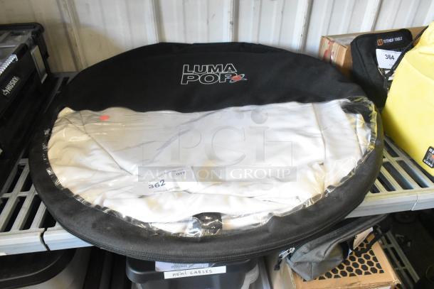 Luma Pop Unit in black case on shelf, visible brand logo. Includes label with auction lot number 362. New condition.