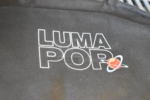 Luma Pop Unit with logo on black fabric, featuring a red planet symbol. Clean condition.
