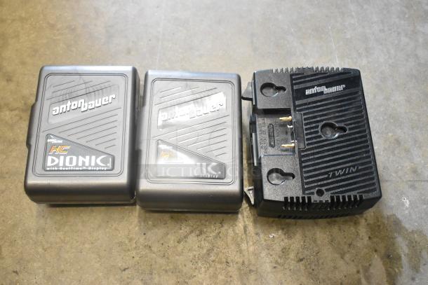Anton Bauer HC Dionic batteries with dual simultaneous charger, real-time display, shown on concrete surface.