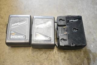 Anton Bauer HC Dionic batteries with dual simultaneous charger, real-time display, shown on concrete surface.