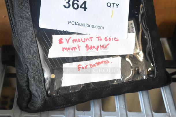 V Mount to Gold Mount Adapter for batteries in black case, labeled with handwritten tags, excellent condition.