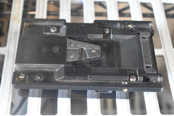 V Mount to Gold Mount adapter, black, metal construction, slightly worn, visible screws, for professional video equipment.