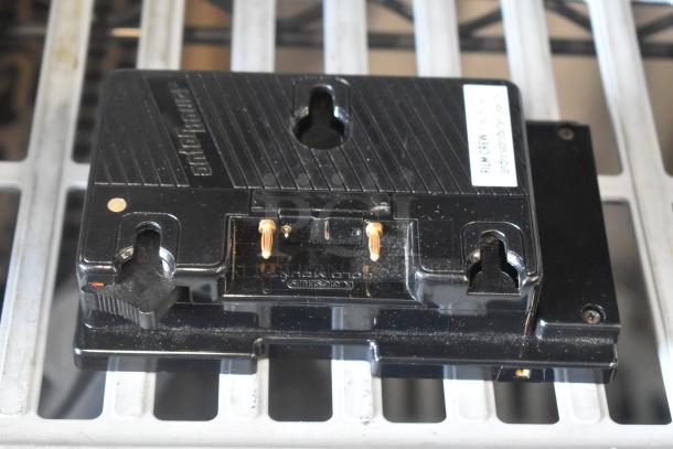 V Mount to Gold Mount Adapter, black, with metal connectors and visible label. Used condition, minor scratches.