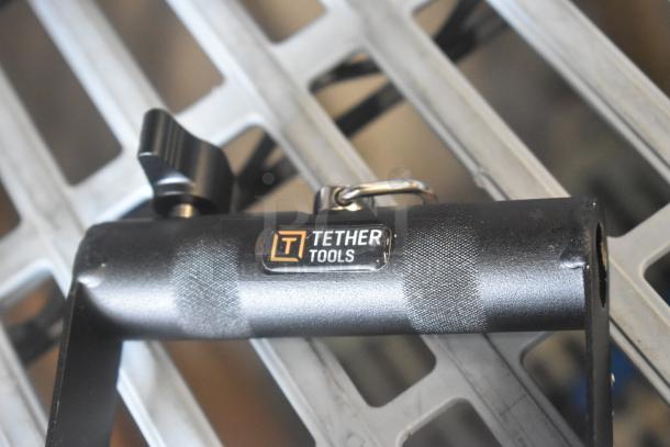 Tether Tools V Mount, black, featuring logo label, used for secure attachment, made of durable metal with adjustment knob.