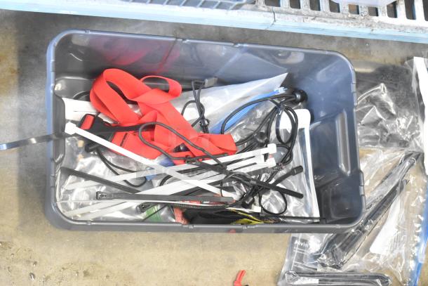 Poly bin with assorted items including Porta Brace fasteners, red straps, cable ties, and other miscellaneous hardware.