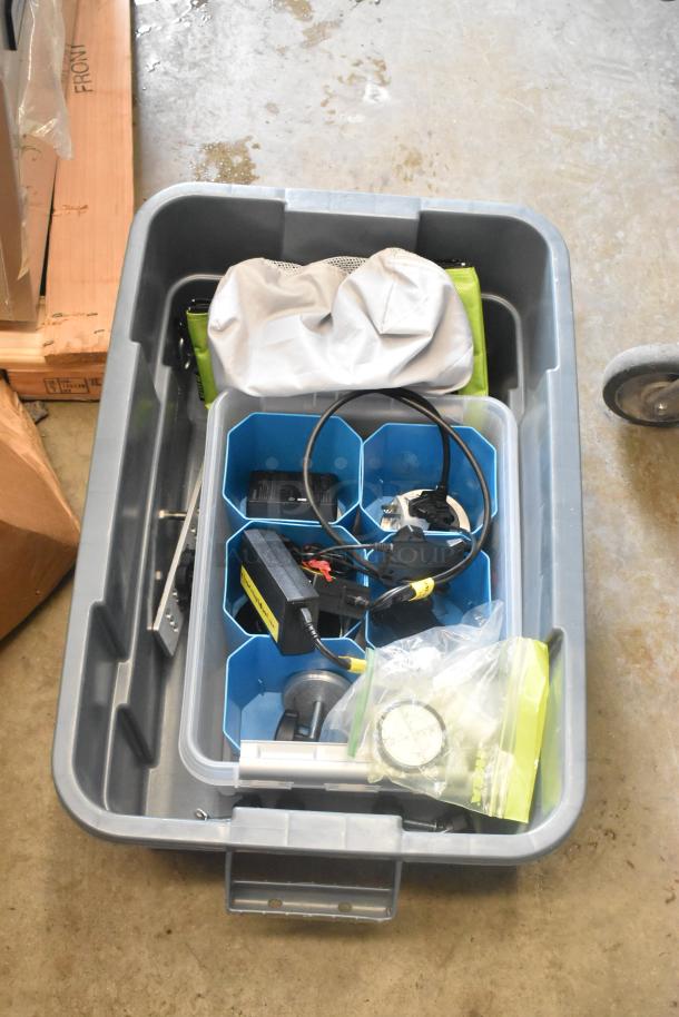 Poly bin filled with assorted hardware, cables, and tools, including chargers and measuring equipment. Suitable for various projects.