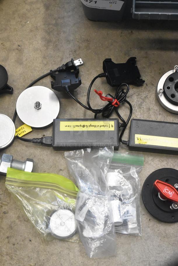 Lot of various hardware items in a poly bin, including cables, connectors, and metal components. Tags with contact info visible.