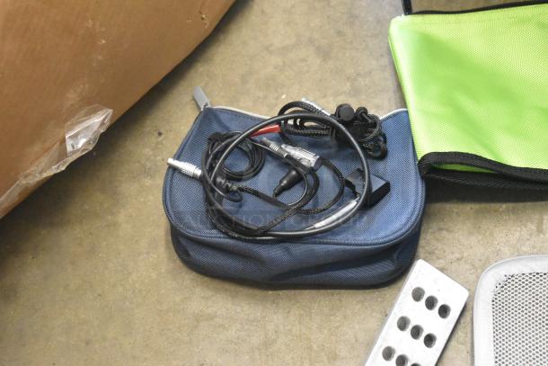 Lot of various items in a poly bin, including hardware and cables on a blue pouch. Condition appears used.