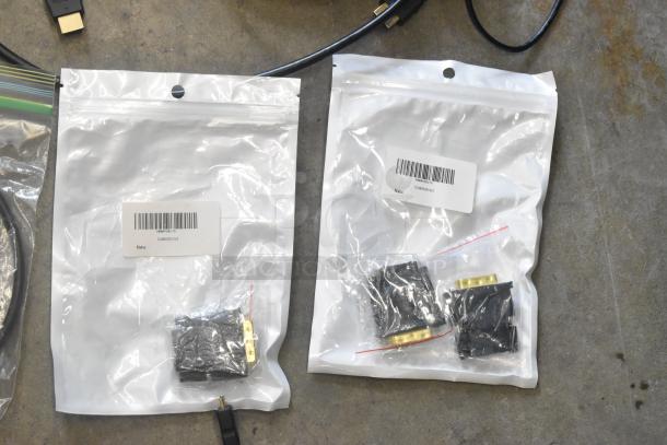 Assorted cables in clear poly bags with barcode labels, "New." Includes connectors; organized in a bin. Condition: new.