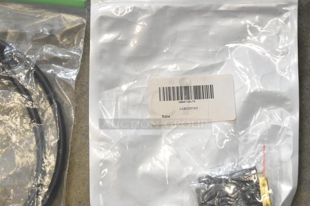 Poly bin with various items including cables, sealed in plastic bags. Visible label on one bag reads "CAB022012x2, New".