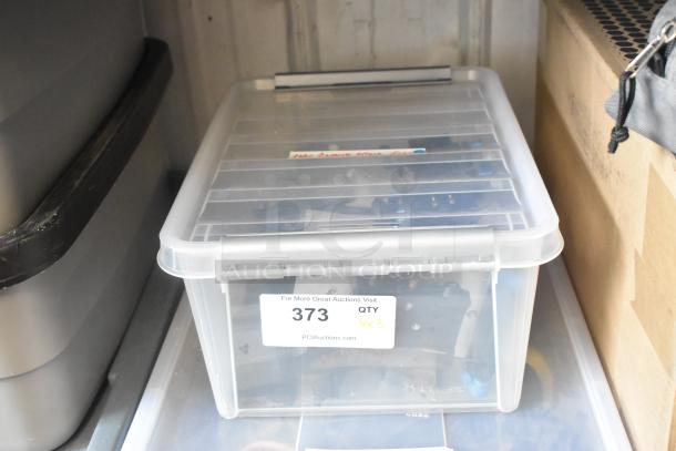 Clear poly bin containing assorted camera attachment gear. Tag with auction lot number 373 visible on the front.