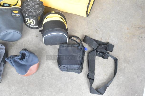 Lot of camera equipment in poly bin, including various cases, straps, and a Mountainsmith branded bag.