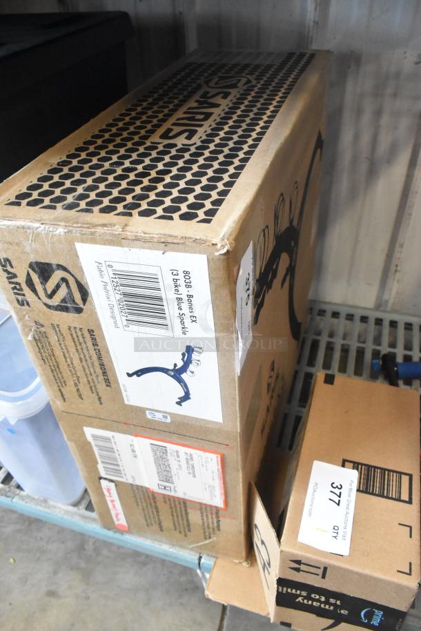 Cardboard box labeled "Saris Bones EX 3-bike blue sparkle," indicating a bike rack. Box condition appears new with visible shipping labels.