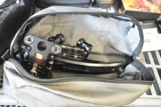 Black mechanical unit in open soft gray bag, showing intricate parts and labeled markings, in excellent condition.