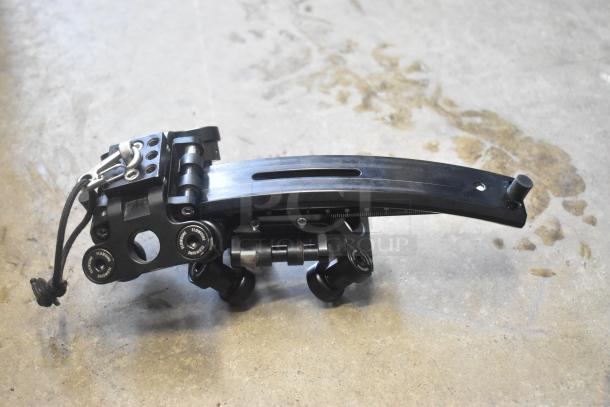 Black mechanical unit with adjustable components and visible markings, showing wear. Labeled "FLOWINE." No bag visible.