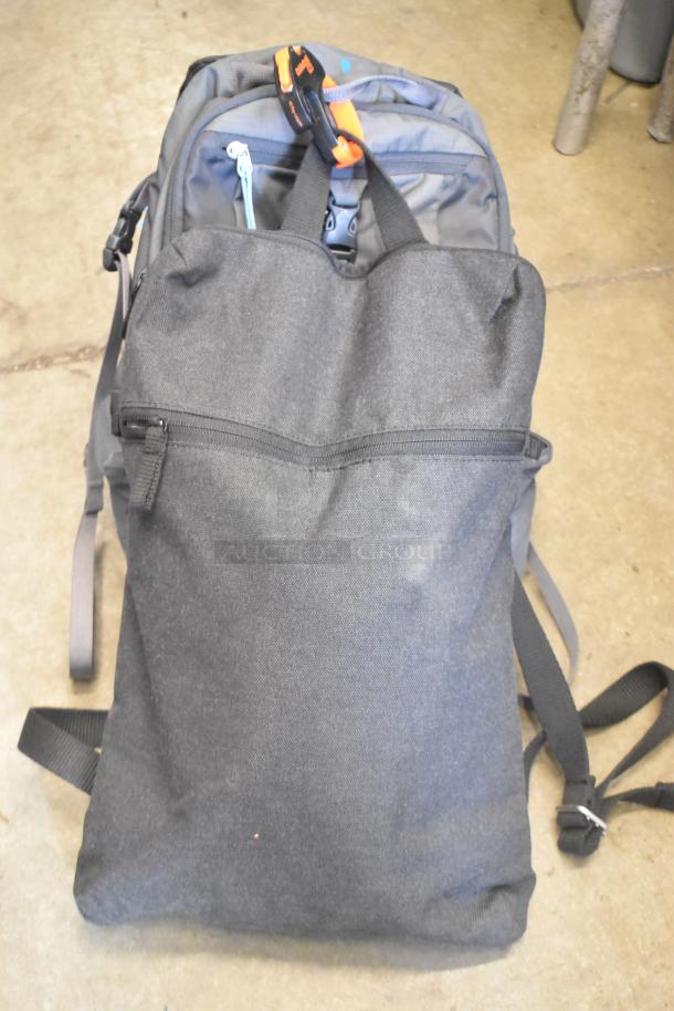Two soft bags, one black with zipper, the other grey with orange accents. Used condition, durable materials.