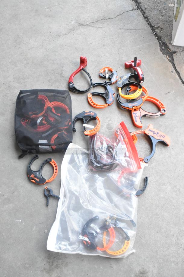 Lot of assorted clamps in poly bucket, featuring various sizes and shapes. Includes Cable Cuff and Maxx Cuff brands.