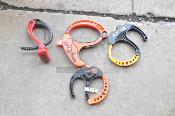 Lot of Cable Cuff Pro and Mega Cuff clamps, various sizes, in used condition, on concrete surface.