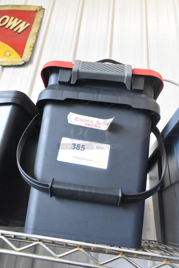 Poly bin with various cords and adapters, labeled "Electric Cord Adapters." Includes auction tag #385 from PCI Auctions.