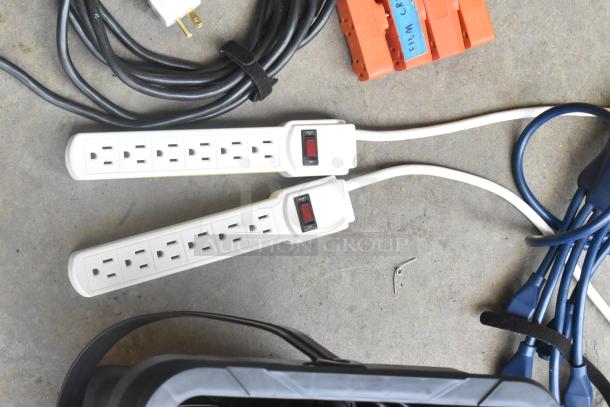 Lot of cords and adapters in a poly bin, including two power strips with switches, black and blue cables, and orange plug adapters.