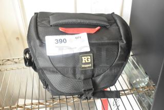 Black Ruggard bag with logo, visible contents label 390, sturdy design, and buckle closure on metal shelf.