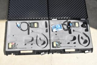Two Sennheiser bodypack transmitters in a hard foam case with cables, labeled "TOY 2-141" and "TOY 2-146."