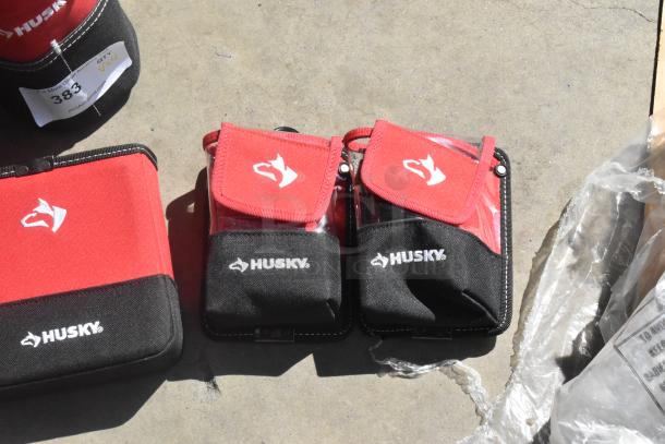 Four red and black Husky bags, new condition, with logo. Auction tag reading "Qty x4." Various sizes for versatile use.