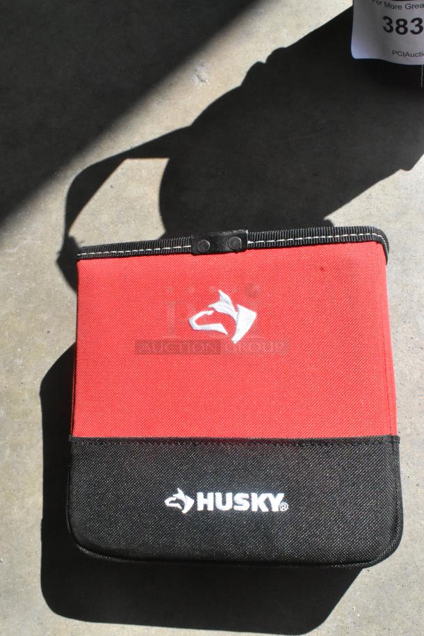 Red and black Husky tool bag with white Husky logo, sturdy fabric, and reinforced edges.